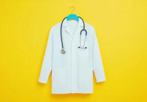 Blouse blanche sur cintre et stéthoscope @ Chaikit / stock.adobe.com. Image générée à l'aide de l'IA.